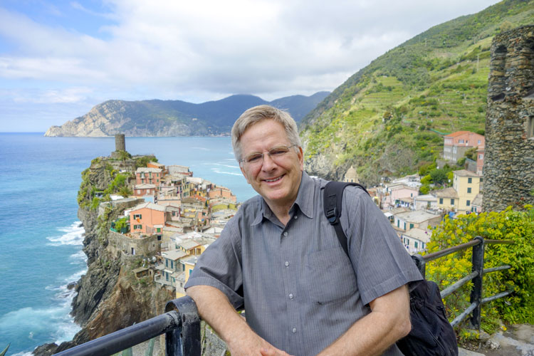 Rick Steves posing in front of the ocean.